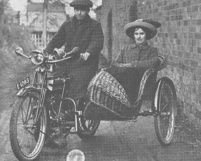 A brand-new Triumph with its proud owner and passenger, taken about 1913. Note the hub gear and contemporary basket-work sidecar.