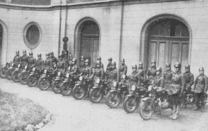 Un groupe de 25 motocyclistes vient prendre livraison de ses machines dans la cour de l'usine. Seule la première moto est une 600 ST 38 ; les autres sont des 600 lat. type 36.