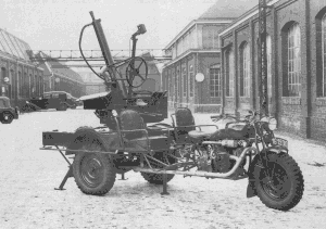 Tricar équipé de la mitrailleuse Hotchkiss 13 mm anti-aérienne, dans la cour de l'usine. Remarquez, sous le châssis, les béquilles amovibles nécessaires pour la stabilité de la plate-forme, lors du tir.